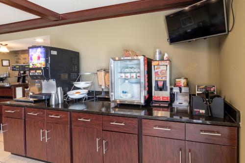 a kitchen with a counter with a refrigerator and a tv at Cobblestone Inn and Suites - Eaton in Eaton