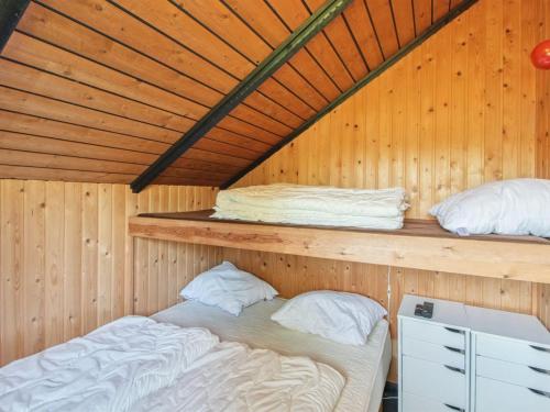 two beds in a room with wooden walls at Holiday Home Melba - 8km from the sea by Interhome in Glesborg