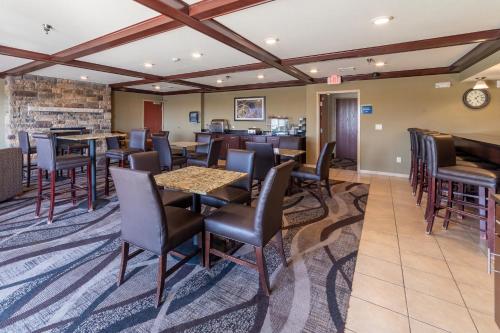 a restaurant with tables and chairs and a bar at Cobblestone Inn and Suites - Eaton in Eaton