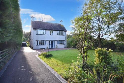 a white house with a pathway leading to it at Spacious Cotswolds House Garden with Hot Tub in Bredon