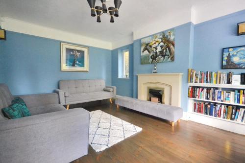 a living room with a couch and a fireplace at Spacious Cotswolds House Garden with Hot Tub in Bredon