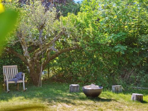 a chair and a tub in a yard with a tree at Holiday Home Lelle - 350m from the sea by Interhome in Beder