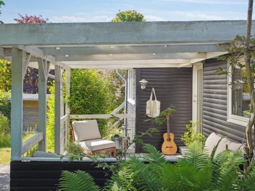 a pergola with a chair and a guitar at Holiday Home Lelle - 350m from the sea by Interhome in Beder