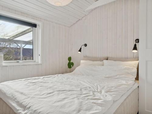 a white bed in a bedroom with a window at Holiday Home Lelle - 350m from the sea by Interhome in Beder