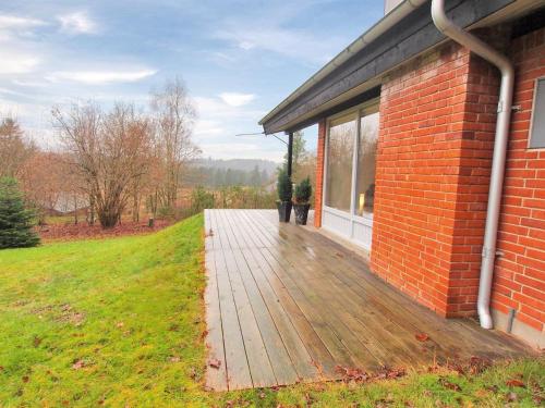 una terraza de madera junto a un edificio de ladrillo en Holiday Home Gerret by Interhome, en Bryrup