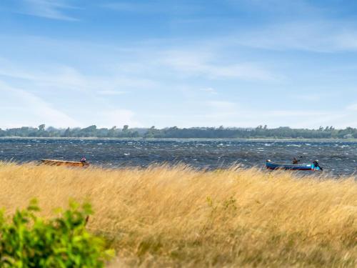three boats are in the water on a beach at Holiday Home Tayana - 75m to the inlet by Interhome in Storvorde