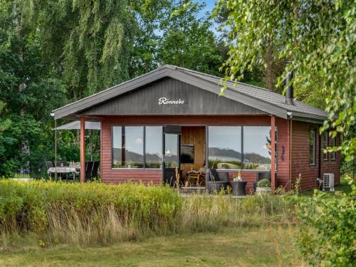 a small cabin with a glass door on a field at Holiday Home Tayana - 75m to the inlet by Interhome in Storvorde