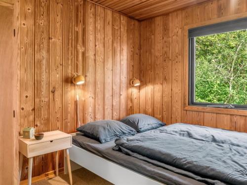 a bedroom with wooden walls and a bed with a window at Holiday Home Tayana - 75m to the inlet by Interhome in Storvorde