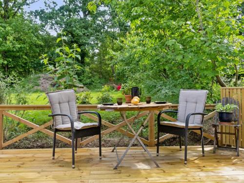 two chairs and a table on a deck at Holiday Home Reika - 1km from the sea by Interhome in Glesborg