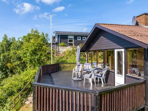 a deck with chairs and tables on a house at Holiday Home Imgert - 300m to the inlet by Interhome in Løgstrup