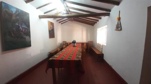 a room with a long table with benches in it at Turismo Vivencial Raqchi Raices Inka in San Pedro