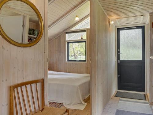 a bedroom with a bed and a mirror and a door at Holiday Home Arleta - 250m to the inlet by Interhome in Skals