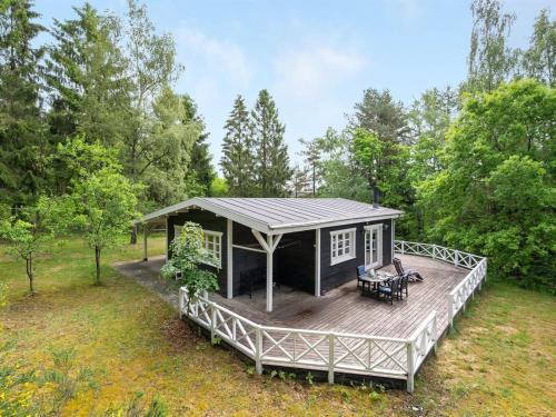 a cabin on a wooden deck in the woods at Holiday Home Belenda by Interhome in Silkeborg