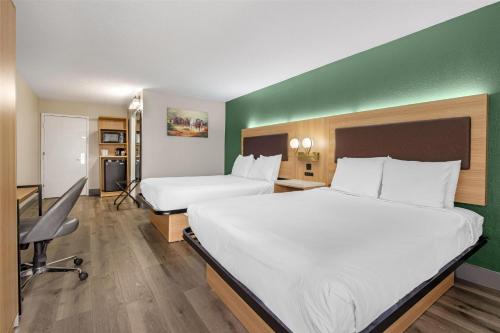 a hotel room with two beds and a green wall at Best Western Richmond Hotel in Richmond