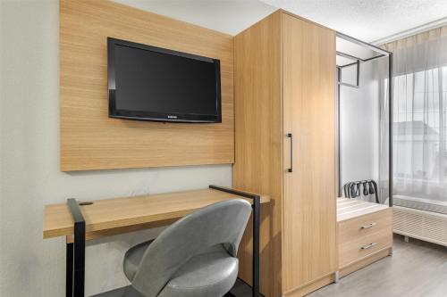 a room with a desk and a television on a wall at Best Western Richmond Hotel in Richmond