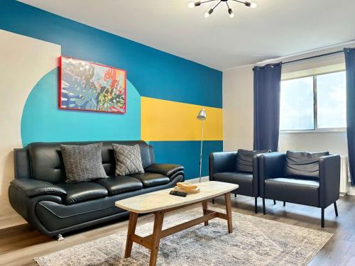 a living room with a black leather couch and a table at Downtown! 5 Beds! Onsite Parking! City View! New Renovated! LM1806 in Atlanta