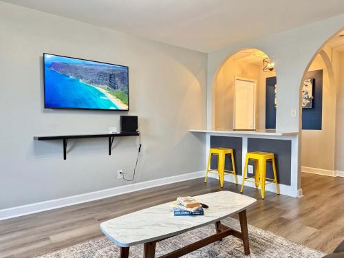 a living room with a table and two yellow stools at Downtown! 5 Beds! Onsite Parking! City View! New Renovated! LM1806 in Atlanta