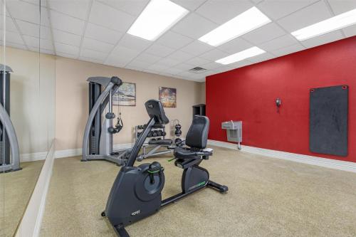 a gym with tread machines in a room with a red wall at Best Western Richmond Hotel in Richmond