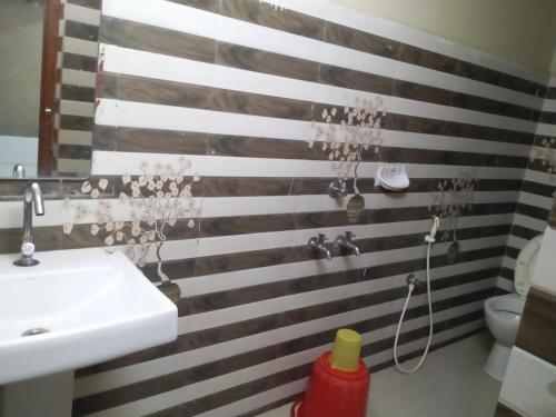 a bathroom with a white sink and a toilet at HoTEL ABHIRAM PALACE in Vijayawāda