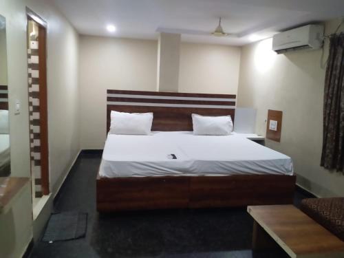 a bedroom with a bed with white sheets and pillows at HoTEL ABHIRAM PALACE in Vijayawāda