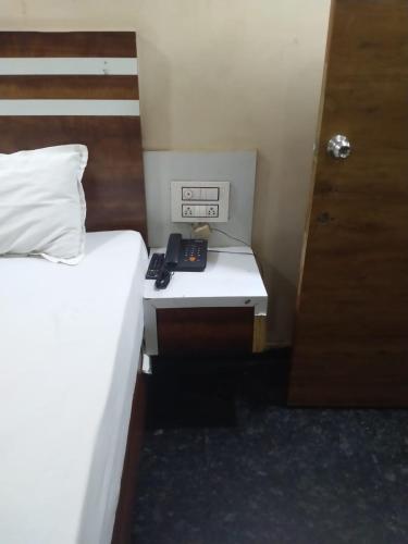 a room with two beds and a desk with a telephone at HoTEL ABHIRAM PALACE in Vijayawāda
