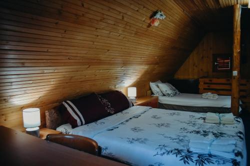 a bedroom with a bed in a wooden room at Villa ORKA Pelister - Forest Zone in Bitola