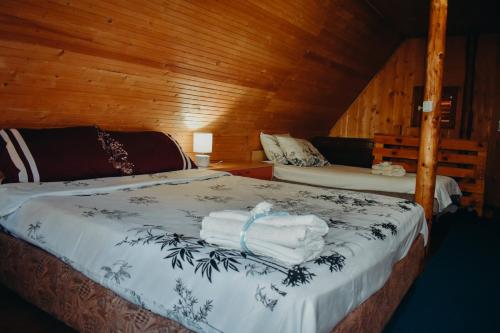 a bedroom with a bed with towels on it at Villa ORKA Pelister - Forest Zone in Bitola
