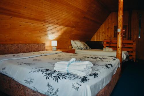 a bedroom with a bed with towels on it at Villa ORKA Pelister - Forest Zone in Bitola