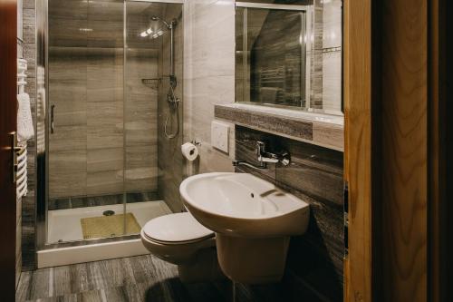 a bathroom with a toilet and a sink and a shower at Pensjonat Jurkowski Wellness & Spa in Ochotnica Dolna