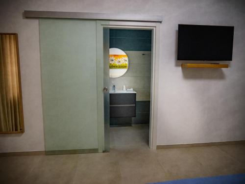 a bathroom with a sink and a television on a wall at Home Relax in Ordona