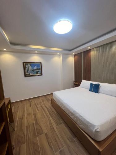 a bedroom with a large white bed with a blue pillow at Samaná Suites Hotel by Habita in Santa Bárbara de Samaná