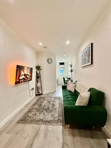 a living room with a green couch and a rug at Luxe Apartment - Leicester City Centre in Leicester
