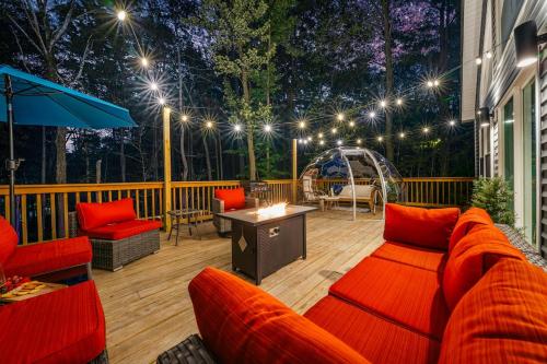 a patio with a couch and chairs on a deck at Chalet with Hot Tub, Game, Movie Room, Lake and Pool Access in Gouldsboro