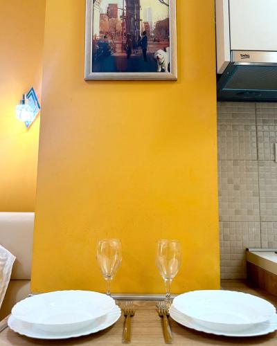 a table with two plates and two glasses on it at Apartments Casa del Sol Jovana in Kotor