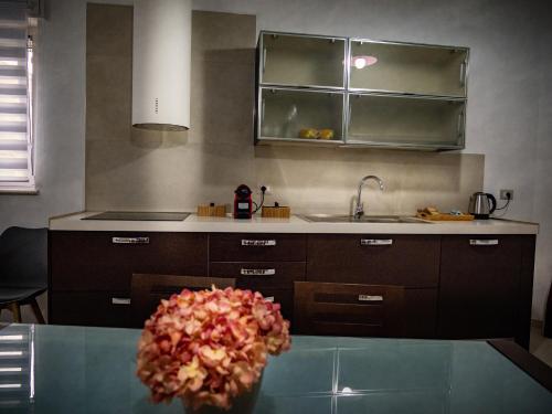 a kitchen with a sink and a table with a flower at Home Relax in Ordona