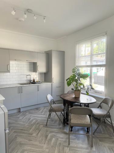 a kitchen with a table and chairs in a room at Luxury Three Bedroom Duplex Apartment Torquay Marina in Torquay