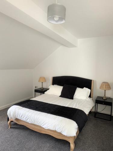 a bedroom with a large bed with two night stands at Luxury Three Bedroom Duplex Apartment Torquay Marina in Torquay