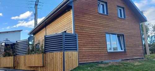 a house with wooden siding and a blue shutter at Appartement cosy in Septfontaines