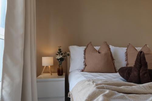 a bedroom with a bed with pillows and a lamp at Quayside Nest - Central Newcastle Apartment with Free Private Parking in Newcastle upon Tyne