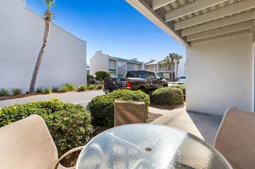 una mesa de cristal y sillas en un patio en Peach Seashell, en Destin