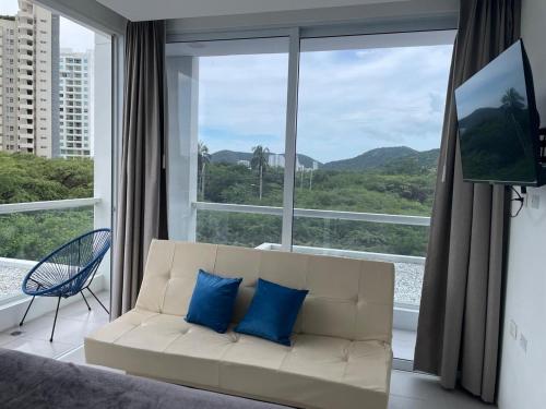 a living room with a couch and a large window at Porto Horizonte Apartamento 310 in Estación El Salto
