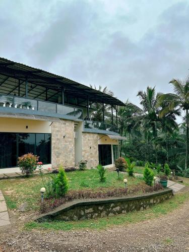 a house with a garden in front of it at Le SAFFRON in Padinjarathara