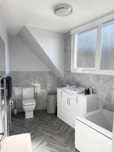 a white bathroom with a sink and a toilet at Luxury Three Bedroom Duplex Apartment Torquay Marina in Torquay