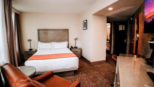 a hotel room with a bed and a couch at The Parker Hotel and Rooftop in Vancouver