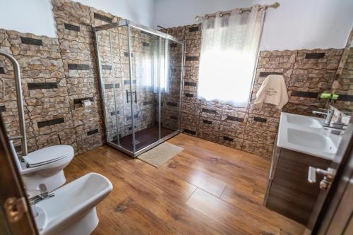 a bathroom with a shower and a toilet and a sink at Villa Ortega Alba in Alcalá la Real