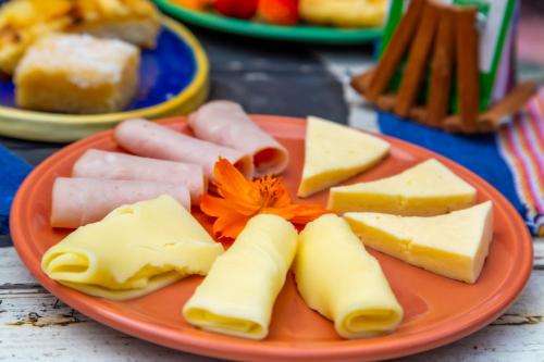a plate of cheese and other foods on a table at Pousada Container Eco Manguinhos in Manguinhos