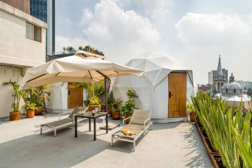 a patio with a table and an umbrella on a building at Umbral Sky Domes in Roma Norte in Mexico City
