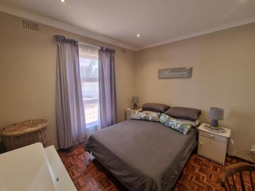 a small bedroom with a bed and a window at Peaceful, Cheerful, Family Friendly 3Bedroom house in Edgemead
