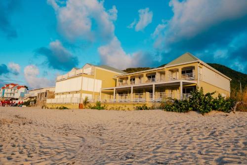 a building on the beach next to the sand at Suite 7 Mogador Residence, 1BR, brand-new, rare & luxury, beachfront in Grand Case
