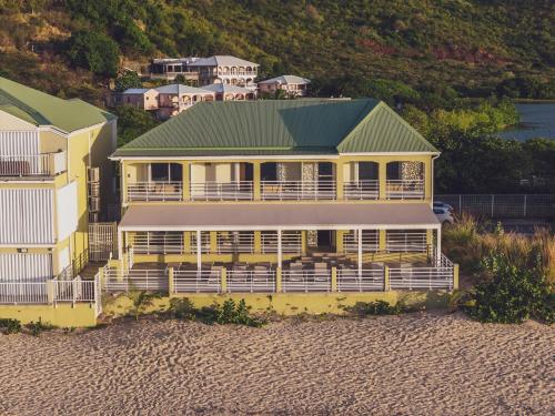 a large yellow house on the beach with houses at Suite 7 Mogador Residence, 1BR, brand-new, rare & luxury, beachfront in Grand Case